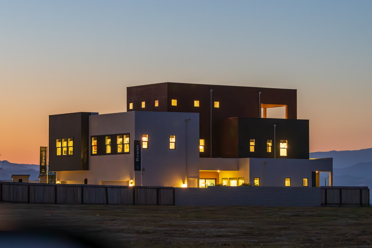 Contemporary architecture glowing at twilight, showcasing sleek design and illuminated windows.